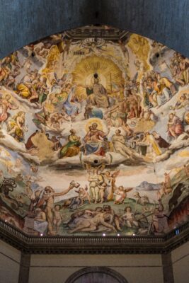 Photo of a fresco in Santa Maria del Fiore, Florence, Renaissance-style art depicting heavenly images above earthly scenes. Many people and angelic figures are portrayed, in a realistic style typical of that period.