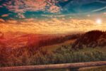 A view during golden hour, looking over a beautiful landscape with blue skies above.